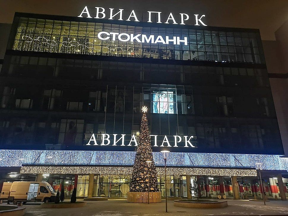 Новогодняя ель перед фасадом торгового центра